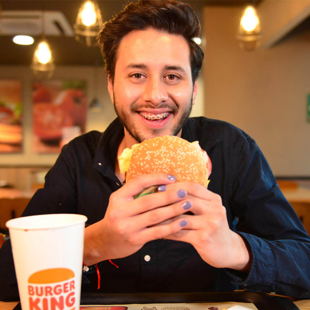 Joven disfrutando una hamburguesa de Burger King